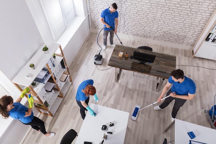 Group Of Janitors In Uniform Cleaning The Office With Cleaning Equipments